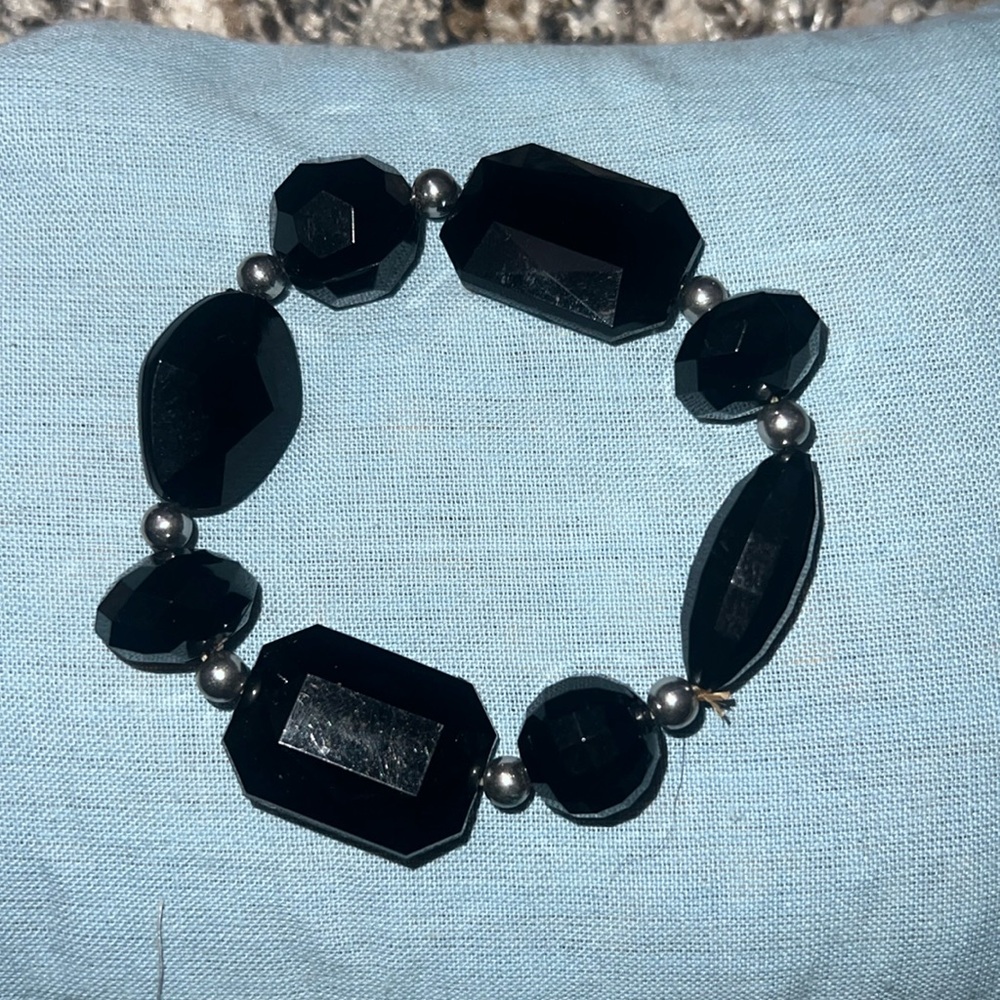 This is a black bracelet with silver beads.